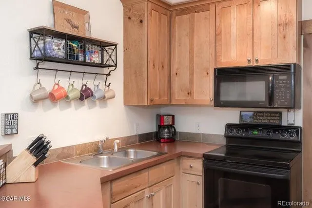 a kitchen with stainless steel appliances a stove a microwave and sink