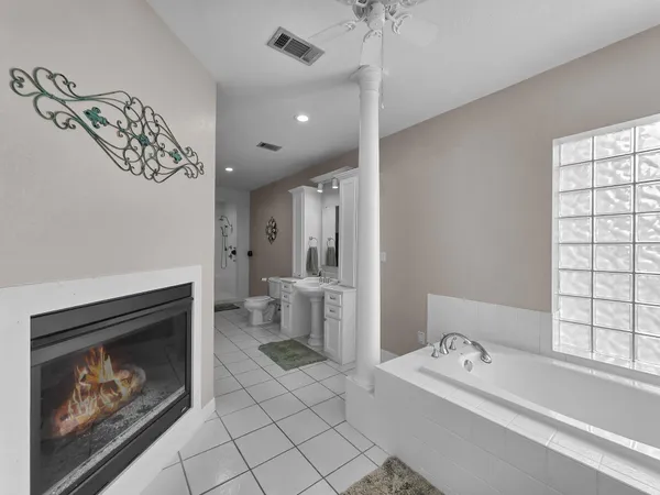 a spacious bathroom with a tub sink and mirror