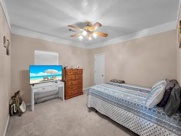 a bedroom with a bed and a ceiling fan