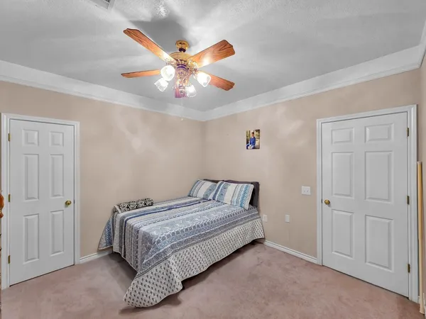 a bedroom with a bed and a ceiling fan