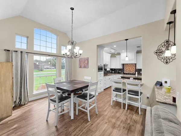 a view of a dining room with furniture a chandelier and wooden floor