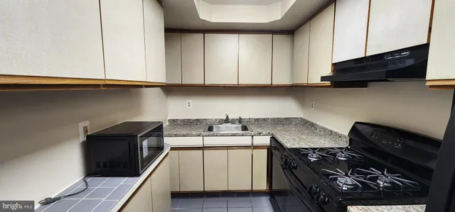 a kitchen with stainless steel appliances granite countertop a stove and a microwave
