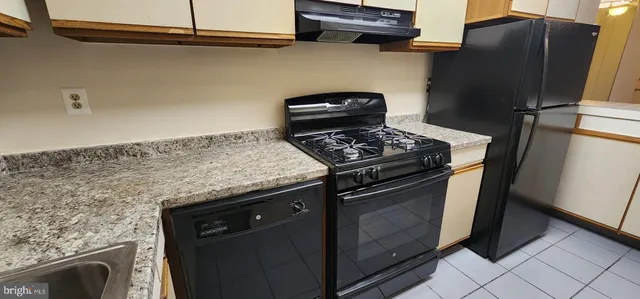 a kitchen with stainless steel appliances granite countertop a stove and a refrigerator
