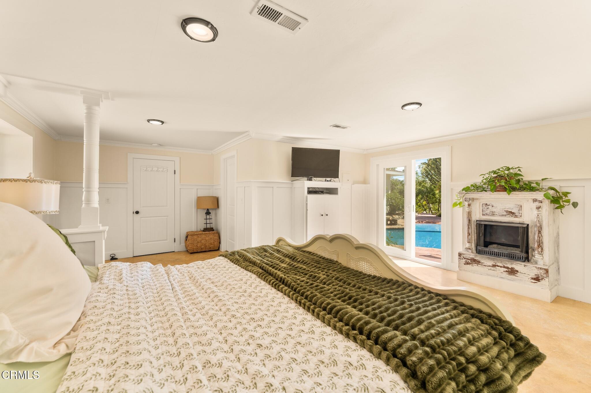 107 Alto Drive Oak View, CA 93022 - Photo 34 of 60 a bedroom with a large bed and a fireplace