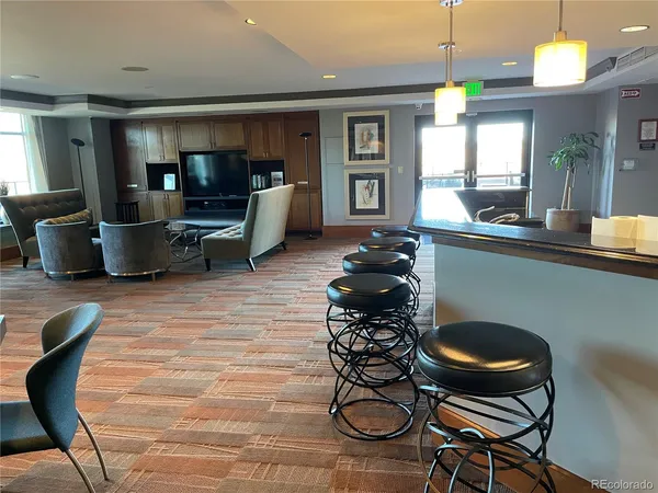 a kitchen with granite countertop a stove a sink and a dining table with chairs