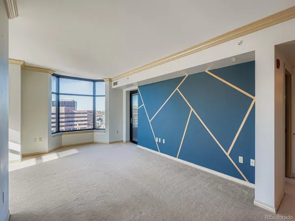 a view of an empty room with staircase and door