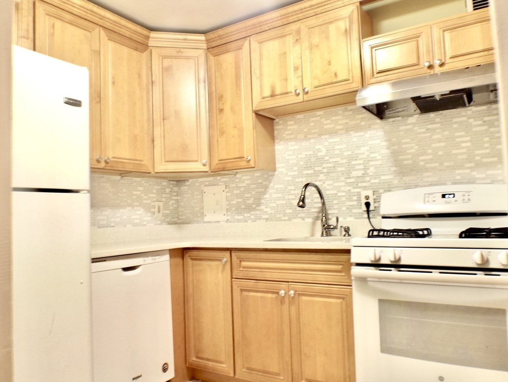 32 Juniper Street, Unit 98 Brookline, MA 02445 - Photo 2 of 17 a kitchen with stainless steel appliances granite countertop a sink and a window