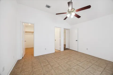 an empty room with windows and fan
