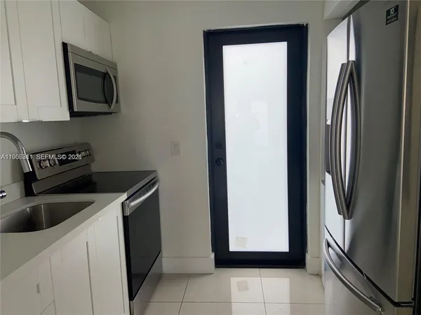 a kitchen with a refrigerator sink and cabinets
