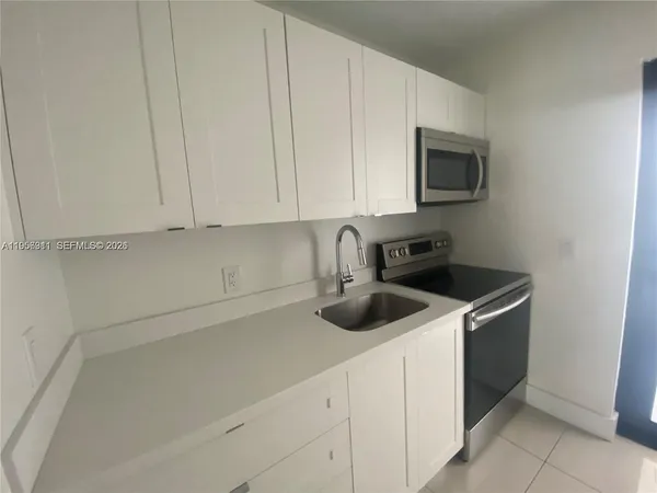 a kitchen with white cabinets and white appliances