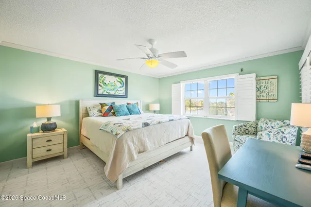 a bedroom with a bed a chandelier and a table