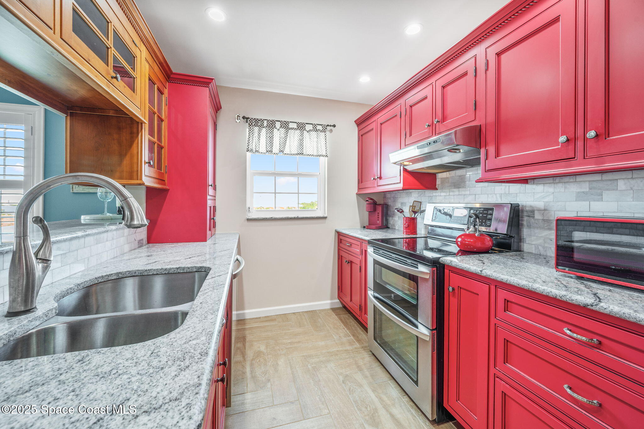 2001 South Banana River Boulevard, Unit 319 Cocoa Beach, FL 32931 - Photo 7 of 45 a kitchen with stainless steel appliances granite countertop a kitchen island a stove a sink and a microwave