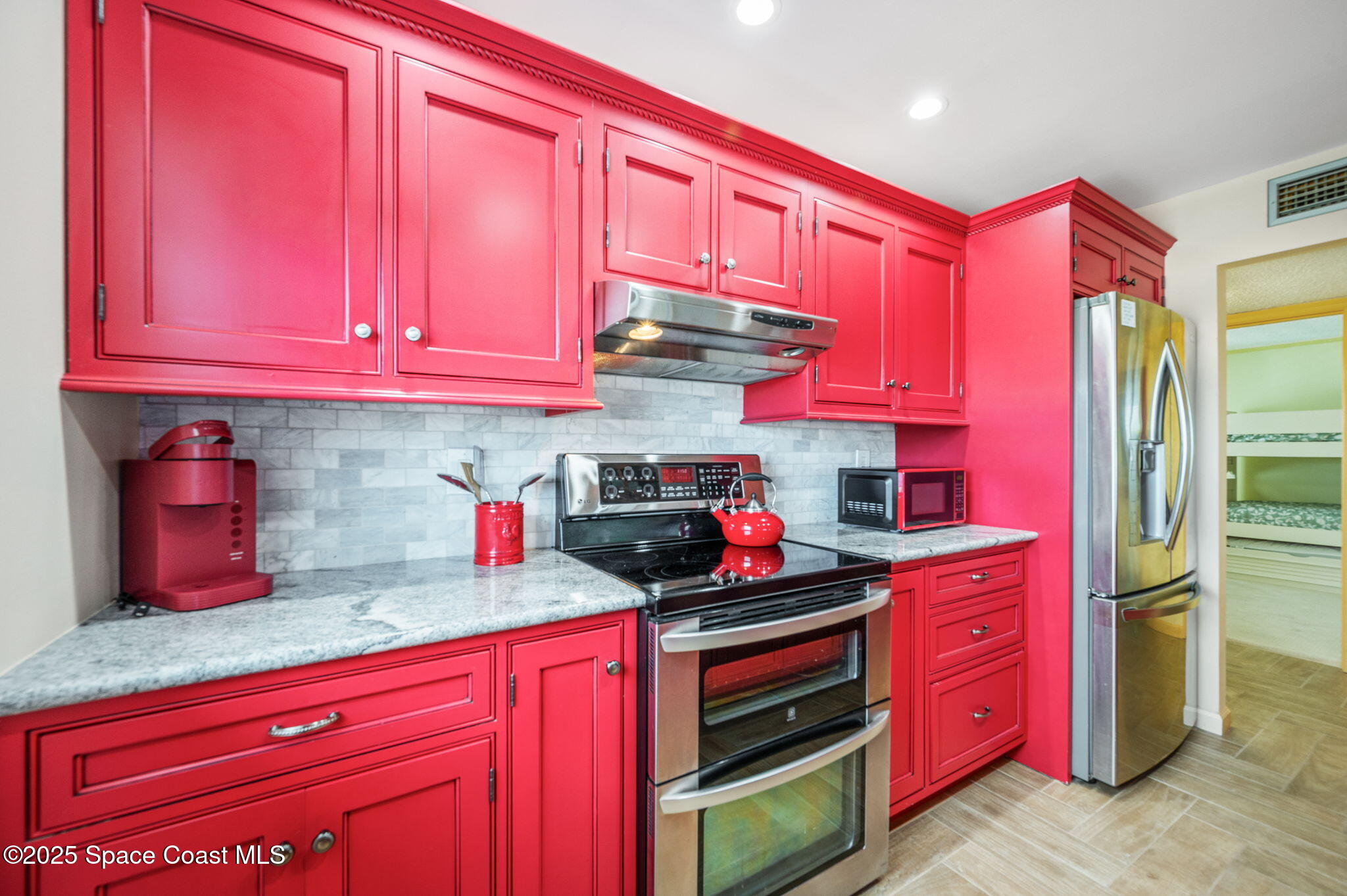 2001 South Banana River Boulevard, Unit 319 Cocoa Beach, FL 32931 - Photo 9 of 45 a kitchen with stainless steel appliances a sink cabinets and wooden floor