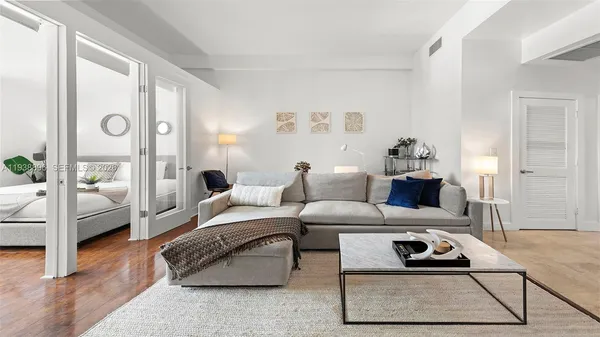 a living room with furniture a rug and a table