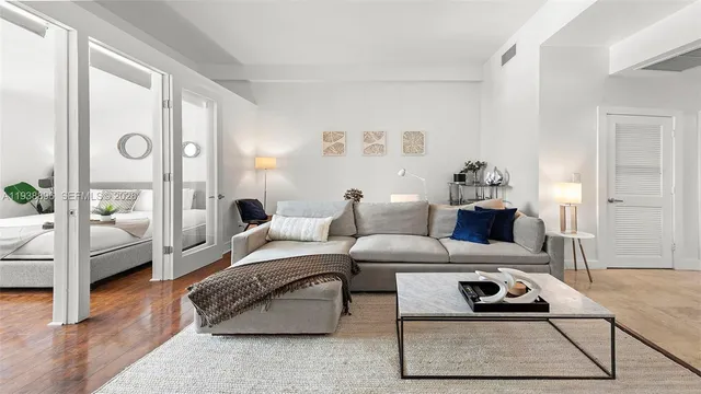 a living room with furniture a rug and a table