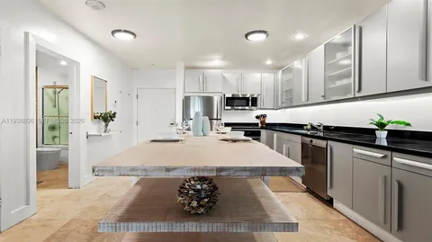 a large kitchen with kitchen island a sink stainless steel appliances and cabinets