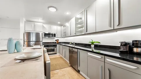 a kitchen with stainless steel appliances granite countertop a sink refrigerator and cabinets