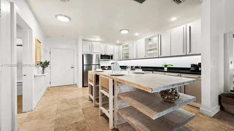 a kitchen with white cabinets and refrigerator