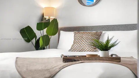 a bathroom with a sink a mirror and a potted plant