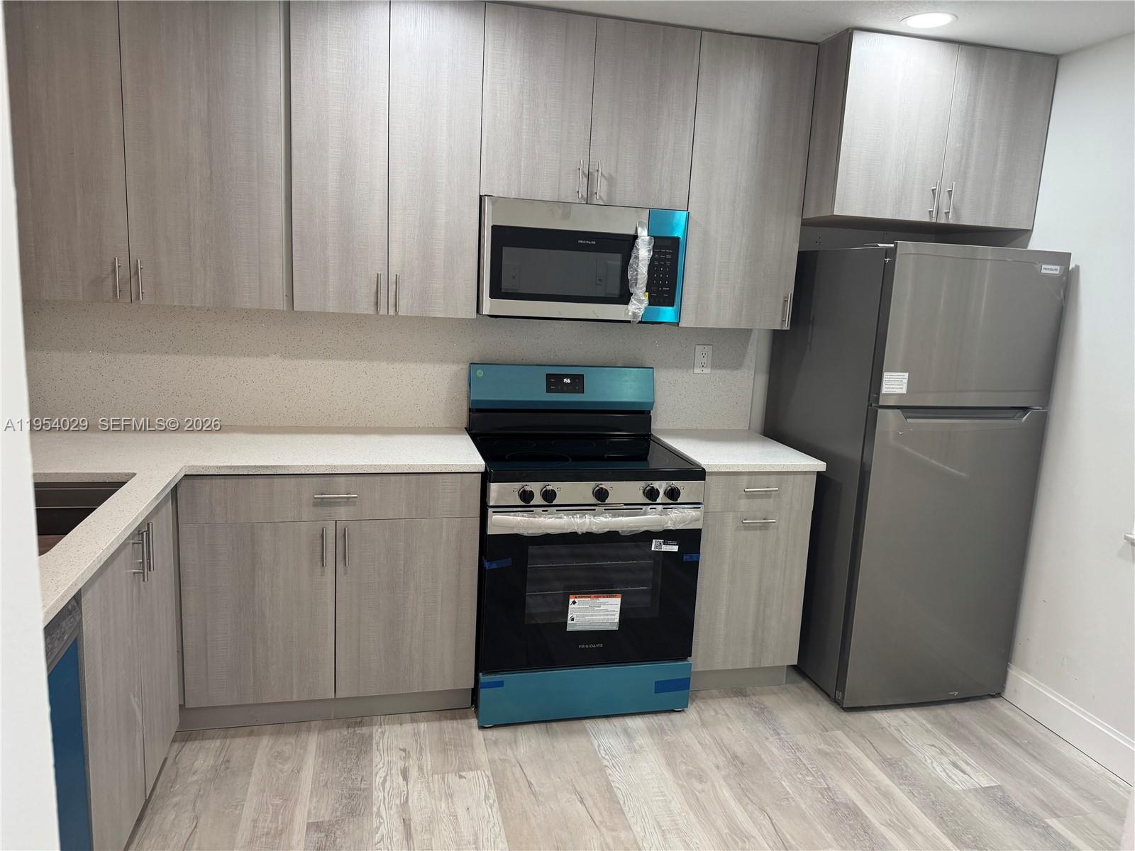 3940 Inverrary Boulevard, Unit 106A Lauderhill, FL 33319 - Photo 12 of 19 a kitchen with a stove refrigerator and microwave