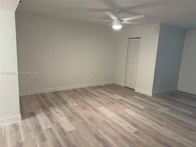 an empty room with a ceiling fan and carpet