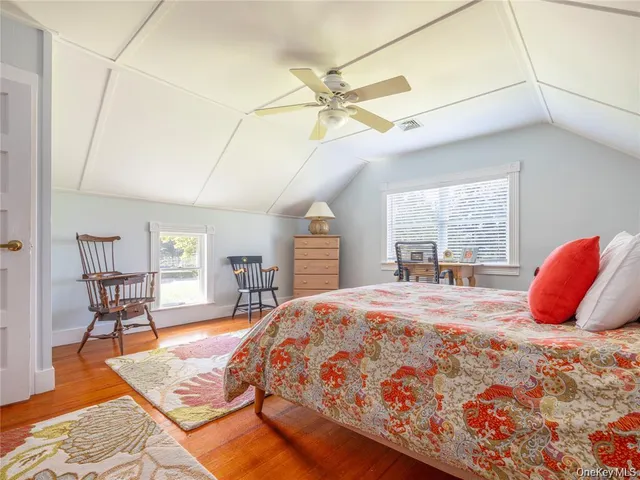 a bedroom with a bed a table and chair with the view of bathroom