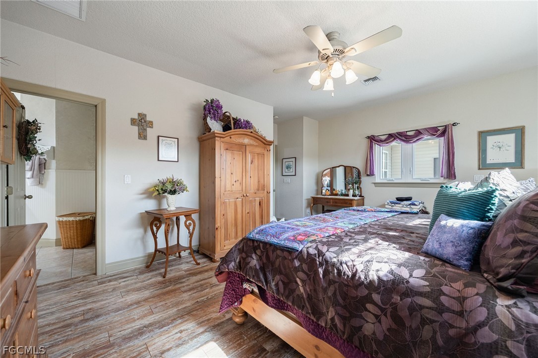 22800 North River Road Alva, FL 33920 - Photo 18 of 50 a bedroom with a large bed and a chandelier