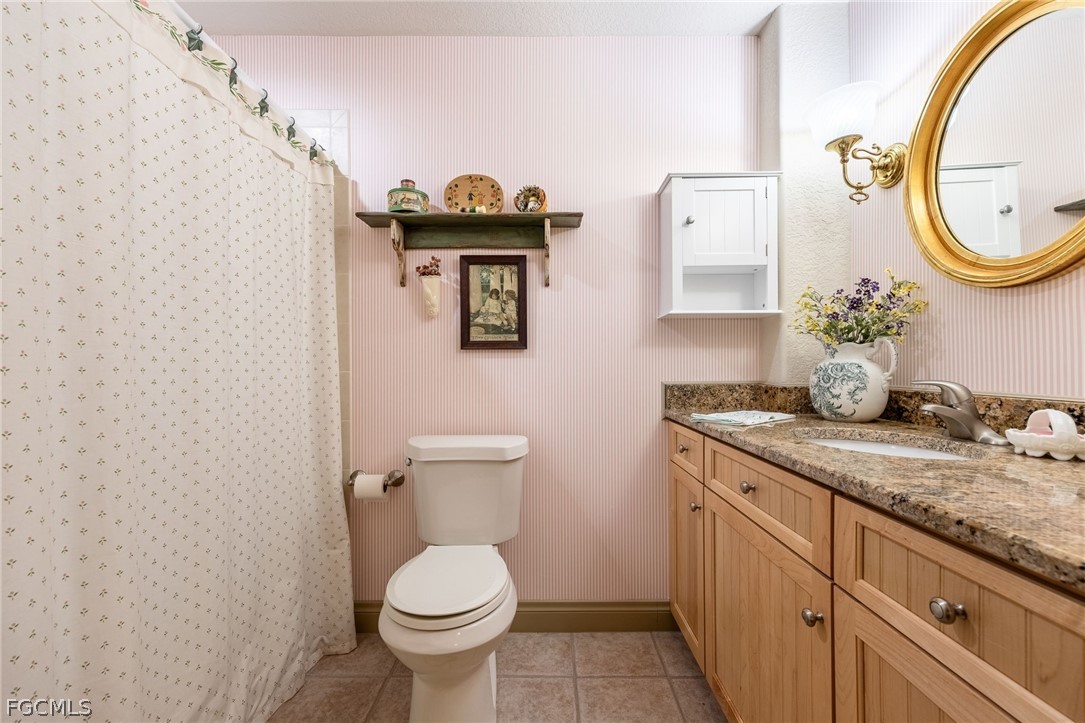 22800 North River Road Alva, FL 33920 - Photo 28 of 50 a bathroom with a granite countertop toilet sink and mirror