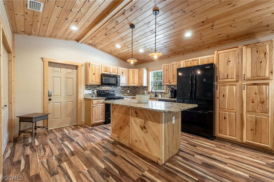 22800 North River Road Alva, FL 33920 - Photo 39 of 50 a kitchen with stainless steel appliances granite countertop a refrigerator a stove and a sink with wooden floors