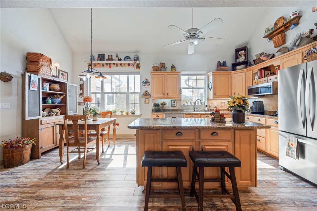 22800 North River Road Alva, FL 33920 - Photo 8 of 50 a kitchen with stainless steel appliances granite countertop table chairs and a refrigerator