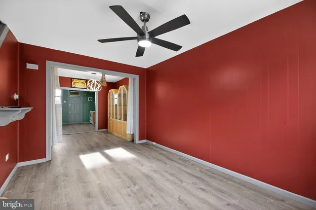 an empty room with a ceiling fan and windows