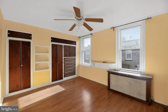 a view of a livingroom with wooden floor and a ceiling fan