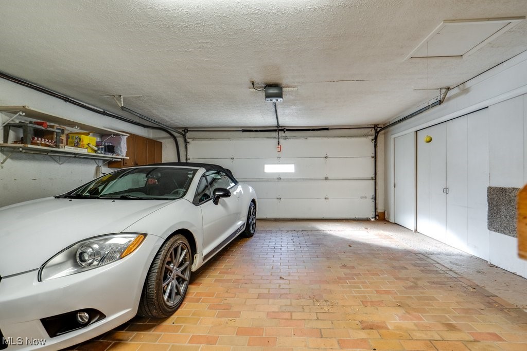 3404 South Smith Road Fairlawn, OH 44333 - Photo 28 of 37 Garage with a garage door opener and Brick floor ad a work bench. There is a wall of closet space for just about everything you would want to use in your garage. The car does not convey!
