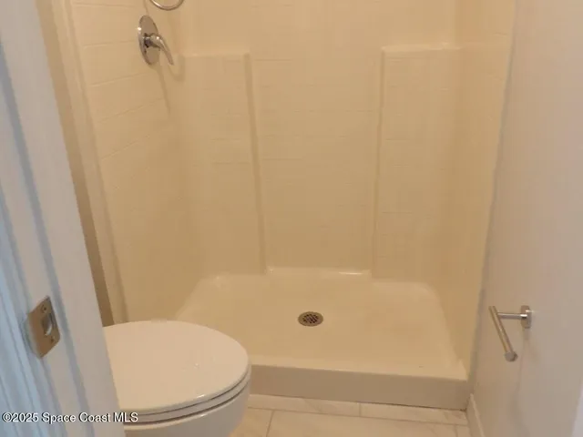 a white toilet sitting next to a bath tub