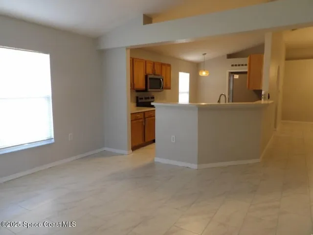 a view of a living room with kitchen island hardwood floor and a window