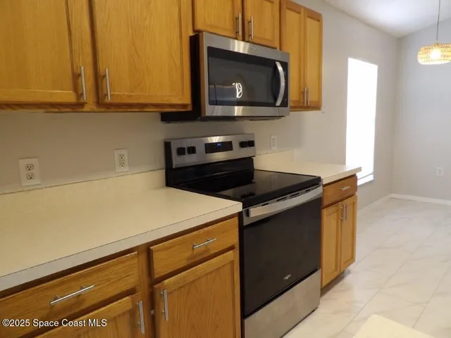 a kitchen with granite countertop cabinets stainless steel appliances and a counter space