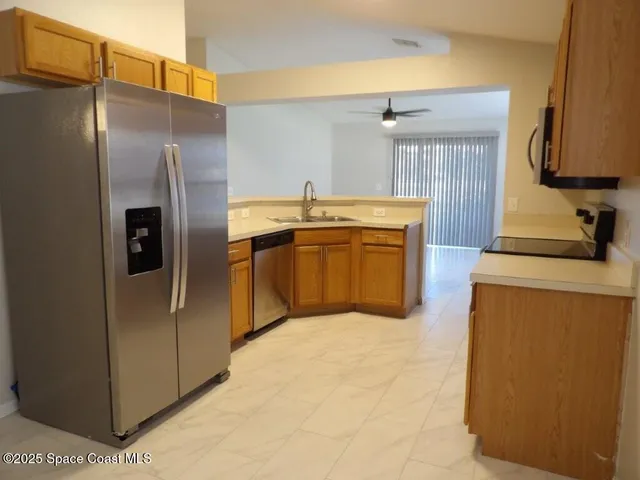 a kitchen with stainless steel appliances granite countertop a refrigerator and a sink