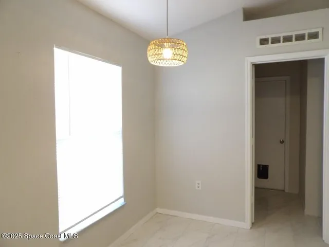 a view of a hallway with a window and chandelier