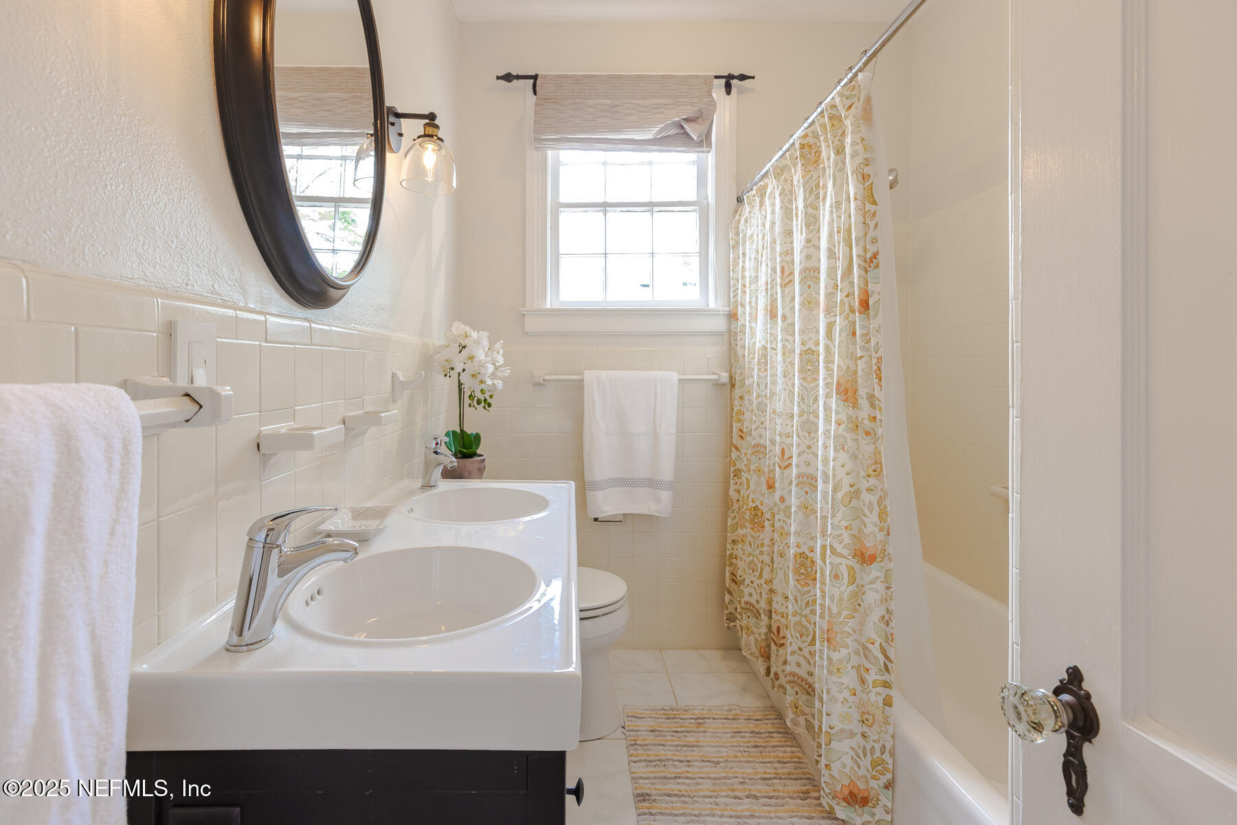 2545 Hendricks Avenue Jacksonville, FL 32207 - Photo 27 of 45 a bathroom with a sink a mirror a vanity and a shower