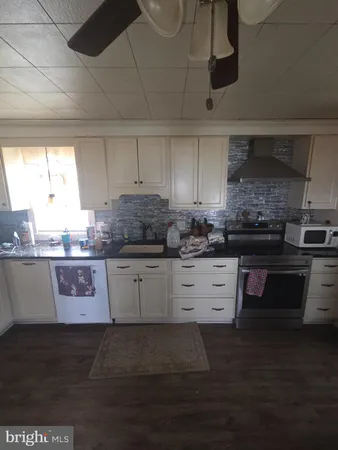 a kitchen with stainless steel appliances kitchen island granite countertop a stove wooden cabinets and a granite counter top