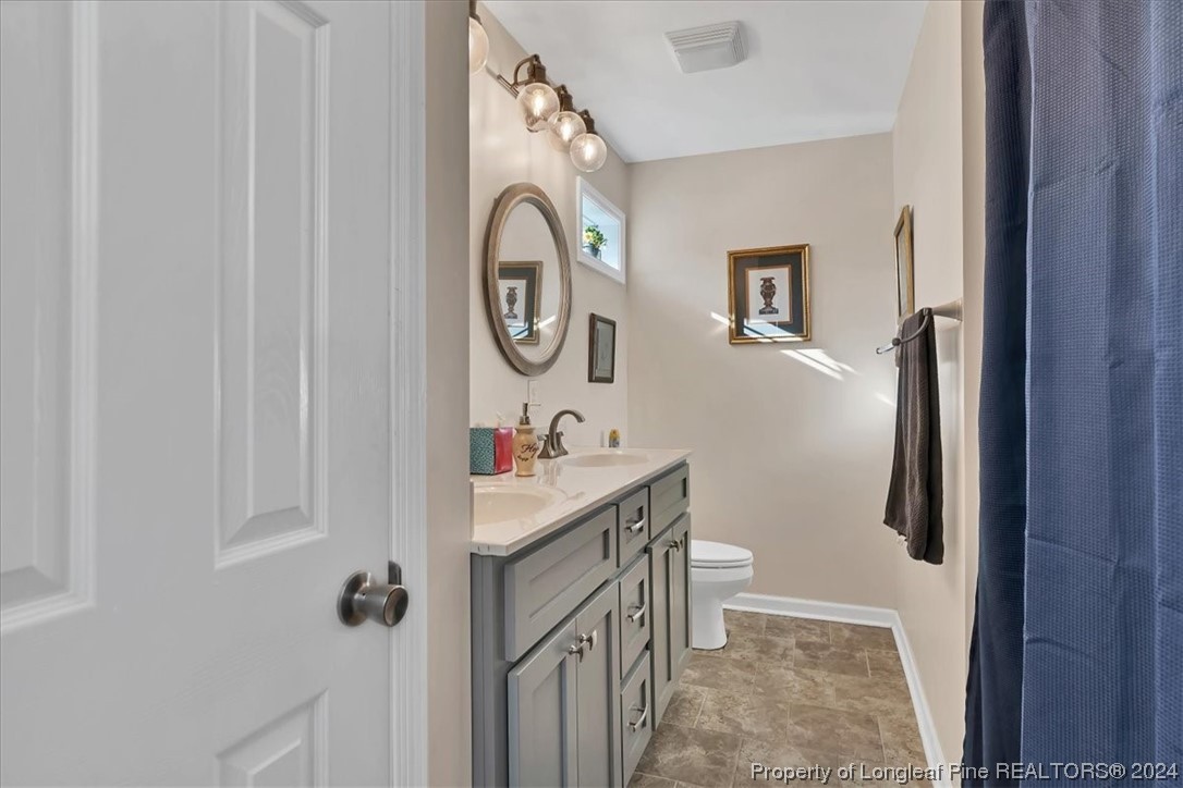 623 Hammonds Road Lumberton, NC 28360 - Photo 30 of 39 a bathroom with a sink a toilet and a mirror