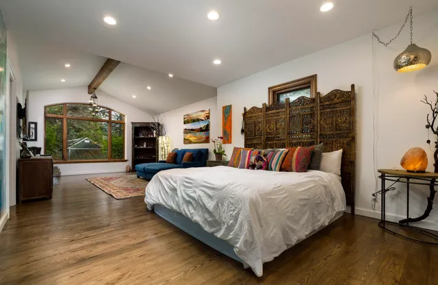 a large bedroom with a bed and wooden floor
