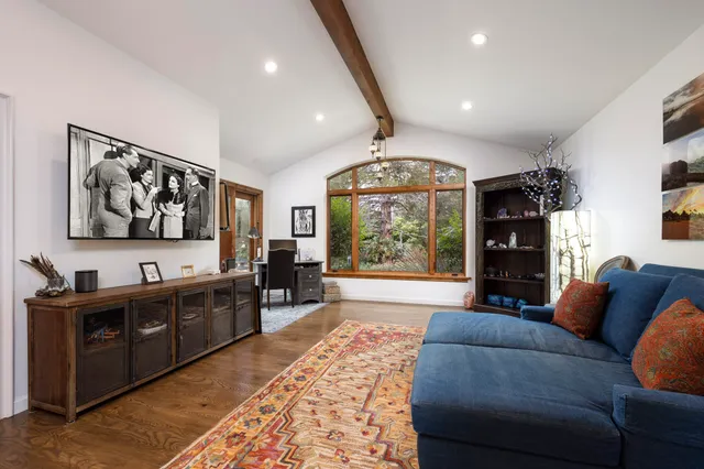a living room with furniture a large window and a chandelier