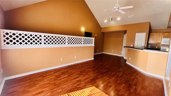 a view of a living room with wooden floor and a window
