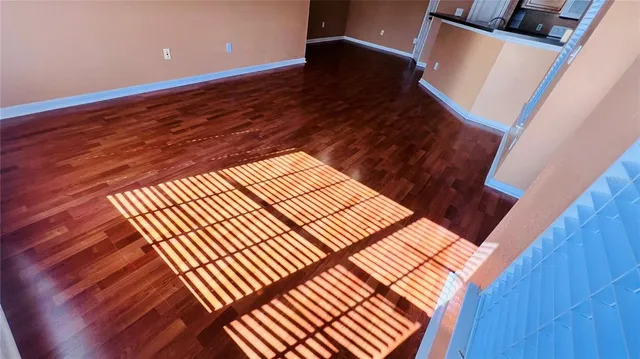 a view of empty room with wooden floor