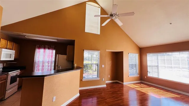 an empty room with wooden floor closet and a ceiling fan