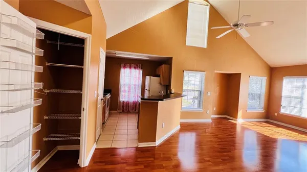 an empty room with wooden floor closet and fan
