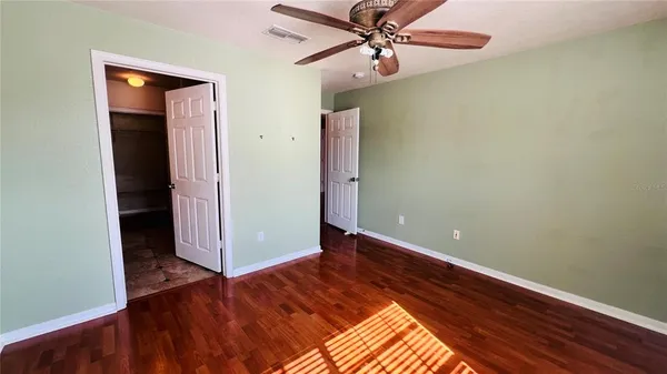 a view of a bathroom with wooden floor and a window