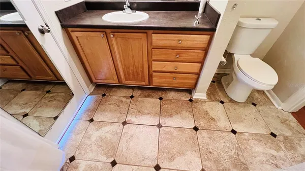 an empty room with wooden floor ceiling fan and window