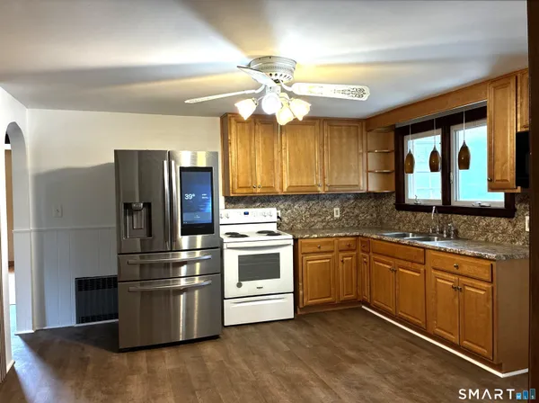 a kitchen with stainless steel appliances granite countertop a refrigerator sink and stove